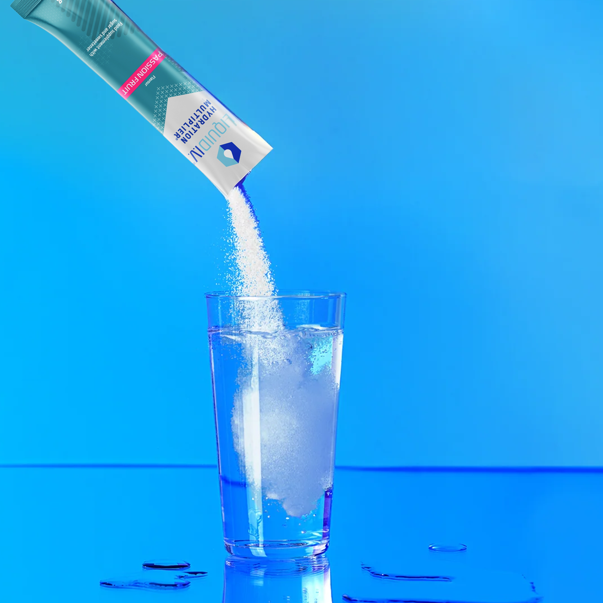 Liquid I.V. powder being poured into a glass of water, creating a refreshing hydration drink.